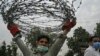 A plain cloth policeman carries barbed wire to seal a street at Aabpara commercial and residential area in Islamabad on June 24, as COVID-19 coronavirus cases continue to rise. 