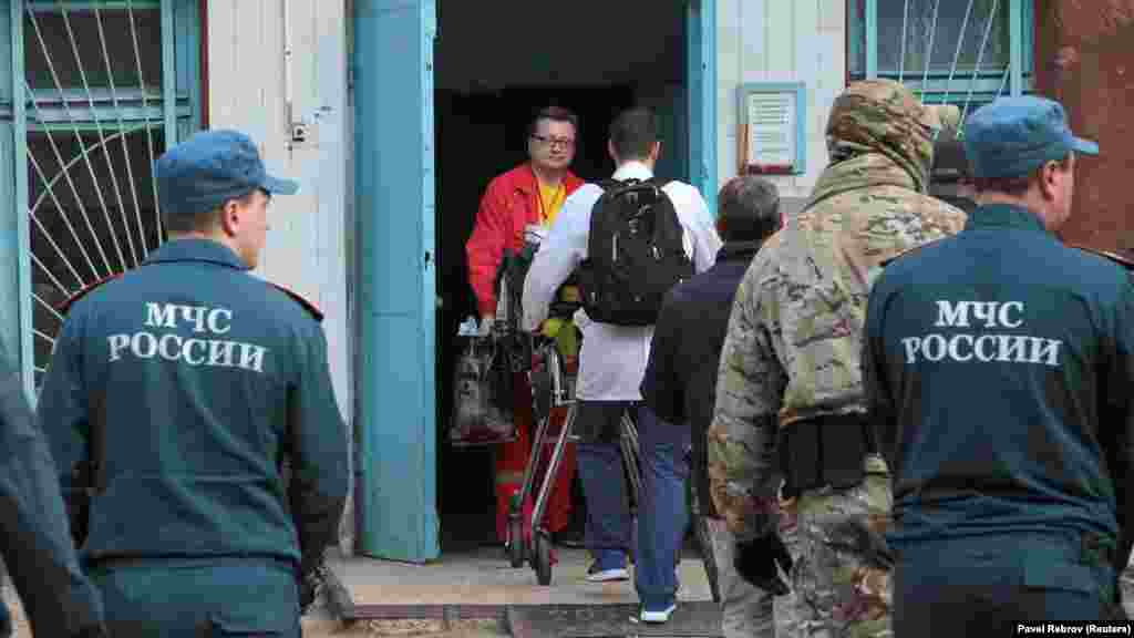Медики транспортируют раненных в больницу после нападения на политехнический колледж в Керчи