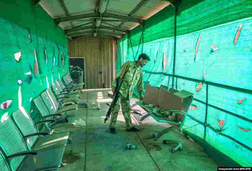 An Afghan soldier looks through items left by the U.S. military at Bagram Airfield on July 5.&nbsp;