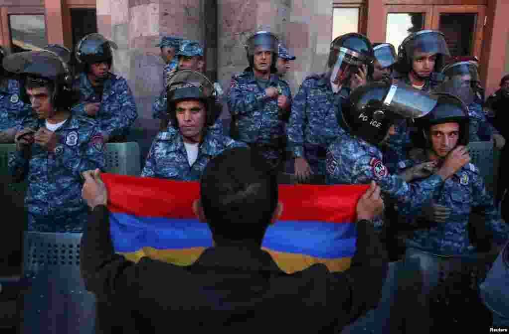A protester confronts law enforcement officers near the government building in Yerevan during a rally to support ethnic Armenians in Nagorno-Karabakh on September 20.