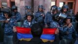 Un protestatar cu un steag armean în fața ofițerilor de poliție, în timpul unei demonstrații în sprijinul armenilor din Nagorno-Karabah, Erevan, Armenia, 20 septembrie 2023. 