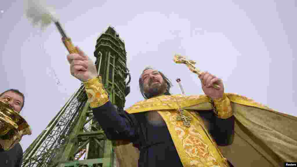 A Russian Orthodox priest conducts a blessing service in front of a Soyuz TMA-06M spacecraft at its Baikonur launch pad in October 2012.&nbsp;