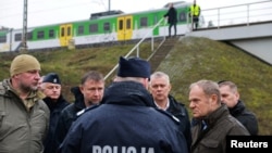 პოლონეთის პრემიერ-მინისტრი დონალდ ტუსკი (მარჯვნივ) ათვალიერებს აფეთქების შედეგად დაზიანებული რკინიგზის მონაკვეთს ვარშავა-ლუბლინის ხაზზე. მიკა, 17 ნოემბერი. 