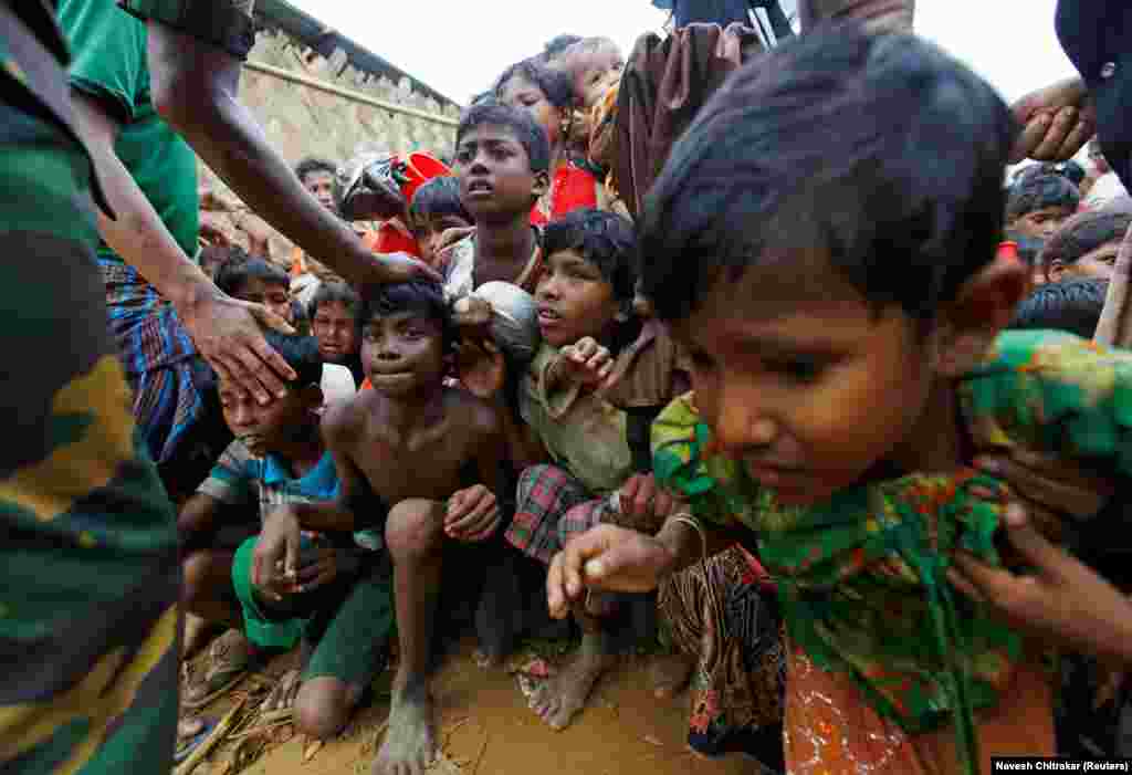 Rohingya refugee children struggle as they wait to receive food outside a distribution center at the Palong Khali refugee camp near Cox&#39;s Bazar, Bangladesh. (Reuters/Navesh Chitrakar)