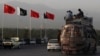 People sit atop a bus as they pass Chinese and Pakistani flags in Islamabad ahead of a trip by Chinese Prime Minister Li Keqiang in 2013.