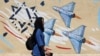 An Iranian woman walks next to an anti-Israeli mural on a street in Tehran on May 26. 