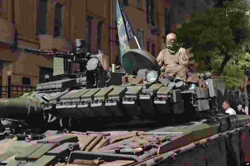 În această captură video, un bărbat stă în vârful unui tanc pe o stradă din Rostov-pe-Don, în timp ce locuitorii orașului rusesc de sud discută cu personalul militar, sâmbătă, 24 iunie 2023.
