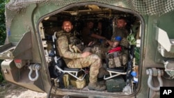 Ukrainian soldiers sit in their armored personnel carrier in Ukraine's Sumy region on August 14, after returning from Russia's Kursk region. 