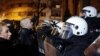 Riot police block Damjan Knezevic and fellow protesters in Belgrade on February 15.