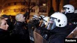 Riot police block Damjan Knezevic and fellow protesters in Belgrade on February 15.