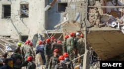  Egy mentőcsapat dolgozik a romok között a gandzsai robbantás után október 11-én.