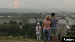 Açinskiň ýaşaýjylary harby ammarda ýüze çykan partlama seredýärler. 5-nji awgust, 2019 ý.