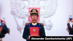 Орусиянын Конституциясын кармап турган аскер адамы. 