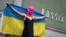 Участница активистской группы Pussy Riot держит украинский флаг во время акции протеста против участия России в Венецианской биеннале перед российским павильоном, 6 мая 2026 года, Венеция