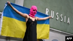 Активістка групи Pussy Riot з українським прапором біля російського павільйону на Венеційській бієнале, травень 2026 року