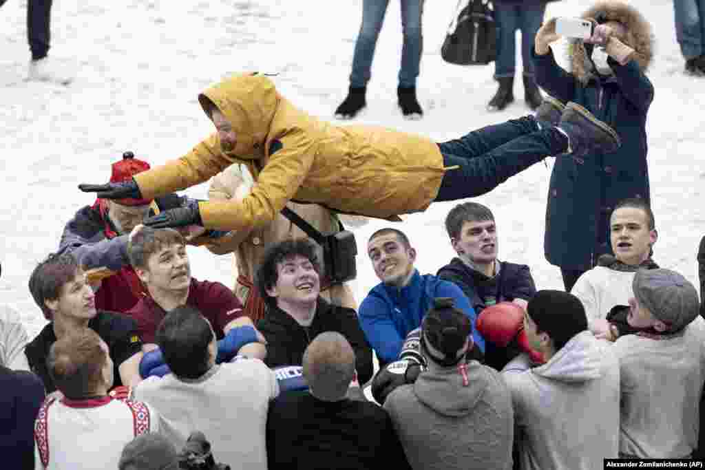 Men toss a young woman at the Izmailovsky Kremlin in Moscow.