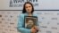 Сьвятлана Ціханоўская з партрэтам журналіста Ўладзімера Янукевіча, былога кіраўніка «Інтэкс-прэс», 13 кастрычніка 2026 году
