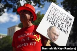 Мужчина держит плакат с изображением российского президента Путина во время протеста против «Брекзиту» в Лондоне, 21 июля 2020 года