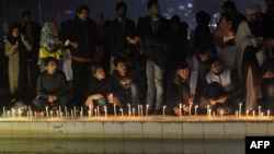 Pakistani civil society activists place lit candles during a vigil in Lahore on December 18 for the children and teachers killed in an attack by militants on an army-run school in Peshawar. 