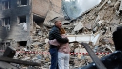 На місці російського ракетного удару по Києву. За повідомленнями, у цих людей у цьому під'їзді жив син. 17 червня 2025 року 