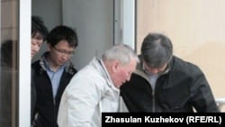 Подсудимый Жаксылык Доскалиев на костылях выходит из здания суда. Астана, 27 мая 2011 года.