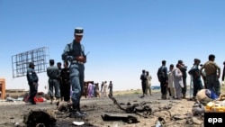 Afghan security officials inspect the site of a suicide bomb blast that targeted a security convoy in Lashkar Gah, in Helmand Province, on July 21.