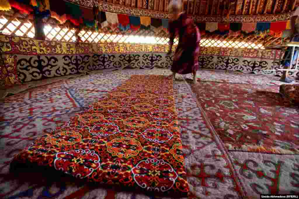 Farida places a blanket on the floor.