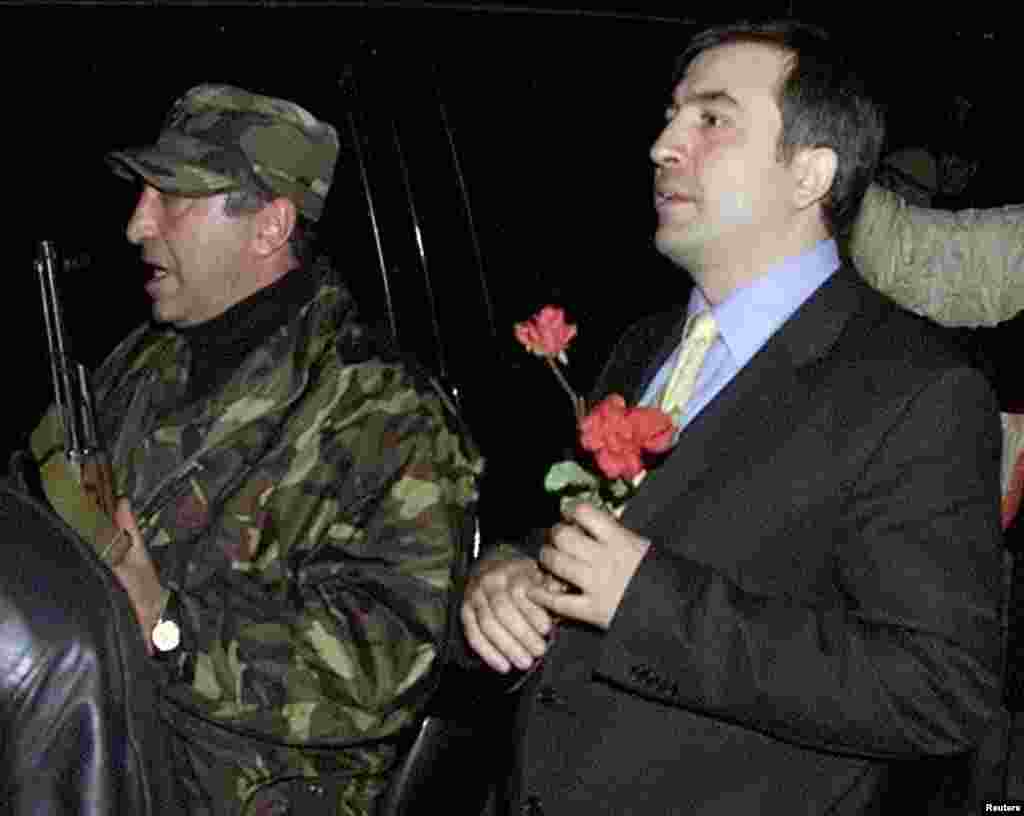 Georgian opposition leader Mikheil Saakashvili (right), surrounded by his bodyguards, leaves after a meeting with President Shevardnadze in the presidential residence in Tbilisi on November 23. Shevardnadze announced his resignation, bowing to opposition protesters who stormed parliament and declared a &quot;Rose Revolution&quot; in the former Soviet republic.