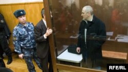 Михаил Ходорковский и его адвокат Вадим Клювгант разговаривают в зале суда, 31 марта 2009