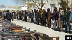 Fighters from the Hizb-e Islami militia surrender their arms to Afghan police in Baghglan Province on March 8.