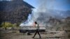 Residents watch houses smolder in Charektar village, known in Azeri as Caraktar, in the district of Karvachar (Kalbacar in Azeri). The mountainous district in Azerbaijan to the west of Nagorno-Karabakh is being vacated by Armenians and returned to Baku&rsquo;s control under a Russian-brokered truce.