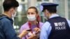 Belarusian athlete Krystsina Tsimanouskaya talks with a police officer at Haneda airport in Tokyo on August 1.