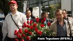 Российский оппозиционный политик Александр Батов (слева) и правозащитник Лев Пономарев идут возлагать цветы к памятнику Абаю. Алматы, 19 мая 2012 года.