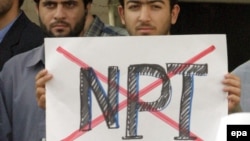 A demonstrator outside the Iranian presidential palace in 2003 holds a sign registering disapproval for the Nuclear Nonproliferation Treaty, of which Iran is a signatory.