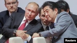 Russian President Vladimir Putin (left) and Japanese Prime Minister Shinzo Abe (right) talk on the sidelines of the Eastern Economic Forum in Vladivostok in September. 