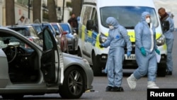 Police forensics officers work at the site where a vehicle rammed the parked car of Ukraine's ambassador outside the Ukrainian Embassy in London on April 13. 