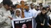 Pakistanis hold a cross and a poster of slain Minister for Minorities Shahbaz Bhatti during a protest in Hyderabad after his killing.