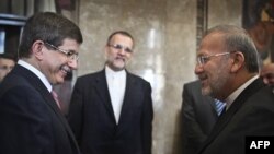 Turkish Foreign Minister Ahmet Davutoglu (left) at a chance meeting in Lisbon with his Iranian counterpart, Manuchehr Mottaki, in mid-July