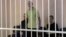 A still image shows Britons Aiden Aslin (left), Shaun Pinner (center), and Moroccan Brahim Saadoun appear in a courtroom cage at a location said to be Donetsk.
