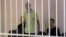 A still image shows Britons Aiden Aslin (left), Shaun Pinner (center), and Moroccan Brahim Saadoun appear in a courtroom cage at a location said to be Donetsk.
