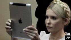 Yulia Tymoshenko uses her iPad to take a photograph during a trial hearing in Kyiv last month.