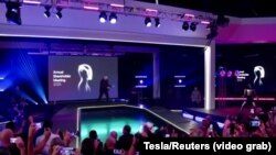 Trenutak kada je izvršni direktor Tesle, Elon Musk, izašao na pozornicu i zaplesao sa svojim robotom na sastanku dioničara u Austinu, Teksas, SAD, 6. novembra 2025.