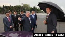 Azerbaijani Transport Minister Ziya Mammadov (center) and Baghlan Group owner Hafiz Mammadov (behind him) present London taxis to President Ilham Aliyev (right).