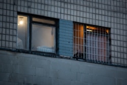 Чоловік курить за гратами вікна одного з корпусів лікарні