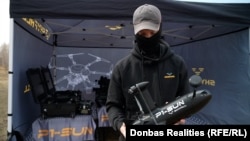 Un reprezentant al companiei SkyFall, demonstrând drona-interceptor P1-Sun, pe un poligon din nordul Ucrainei, pe 25 martie