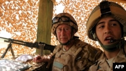 Britain's Prince Charles listens to a British soldier at Camp Pimon in Helmand Province.