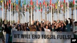 Pe tot parcursul conferinței COP28, activiștii (în imagine cei de la Greenpeace) au cerut eliminarea combustibililor fosili. Declarația finală nu merge așa de departe, vorbind de o renunțarea treptată la ei. (AP Photo/Rafiq Maqbool)