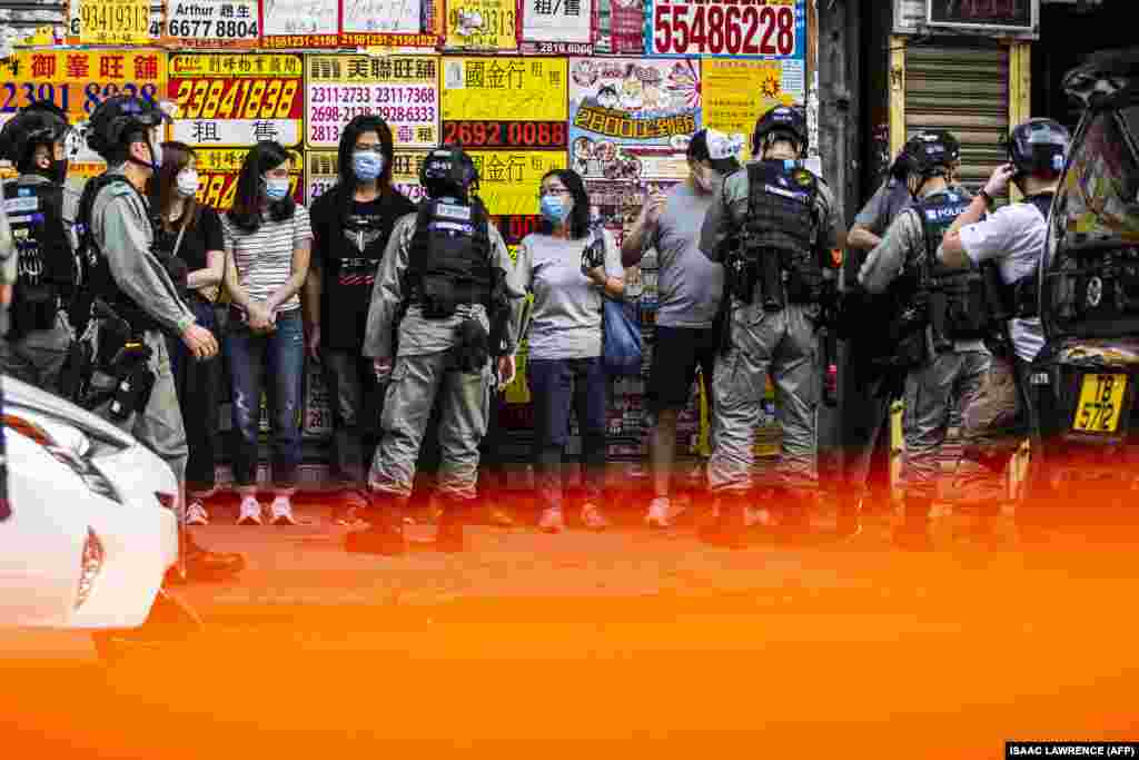 Police stop and search people (C) during a protest against China's planned national security law in Hong Kong on June 28, 2020.