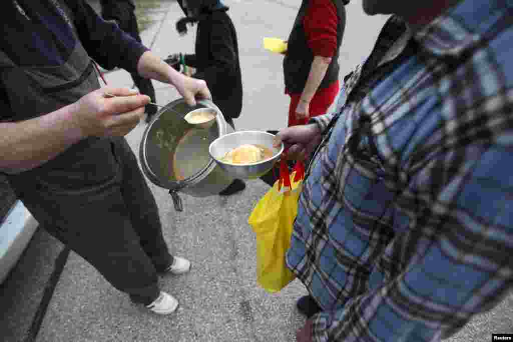 Drazen Matovic receives a food donation in front of the school.