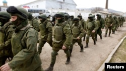 Armed men believed to be Russian servicemen walk outside a Ukrainian military base in Perevalnoye, near the Crimean city of Simferopol, on March 14.